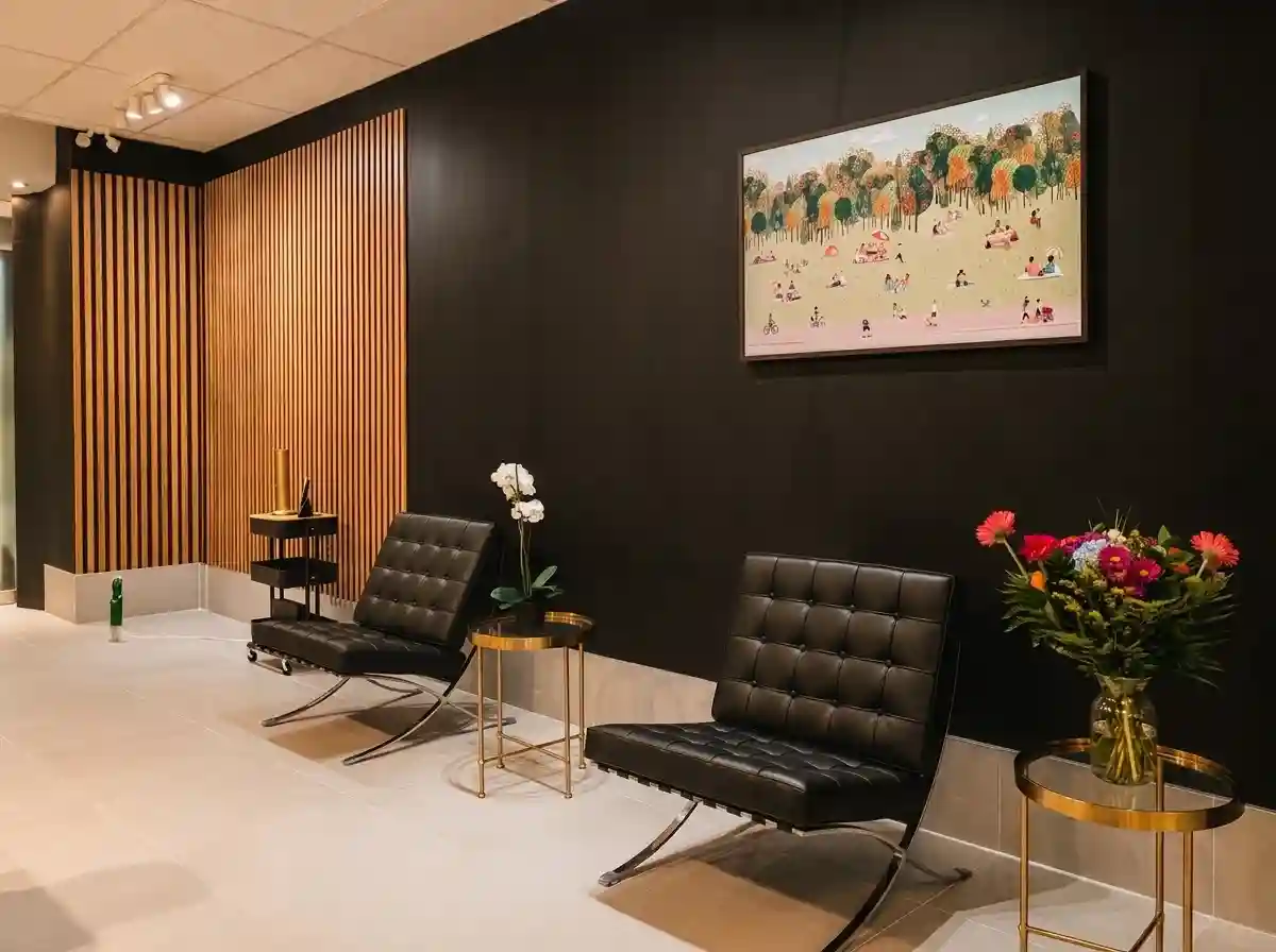 Salon d’attente avec fauteuils en cuir et œuvre encadrée